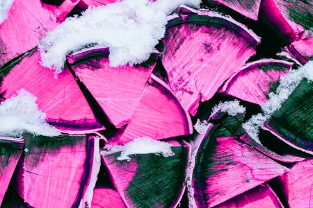 Abstract pink and purple background, texture of firewood in winter with snow. Closeupの写真素材