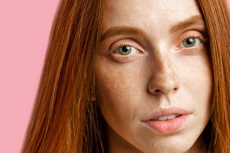 Beauty, skin and hair care concept. Close up shot of beautiful redhead girl with perfect clean skin,...