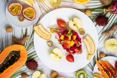 Healthy breakfast from tropical exotic ripe juicy fruits on plates on table. Delicious snack,...