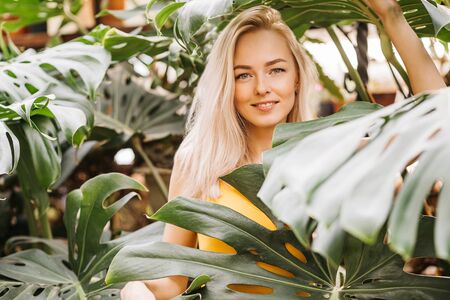 Woman in swimsuit on tropical plants backgroundの写真素材