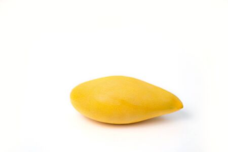 One whole mango fruit. Delicious ripe juicy fresh yellow mango isolated on white background. Exotic tropical fruits.の写真素材