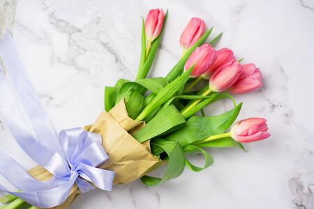 Closeup of a bouquet of purple tulips on a marble white background, top view. Spring, summer, flowers, colorの写真素材