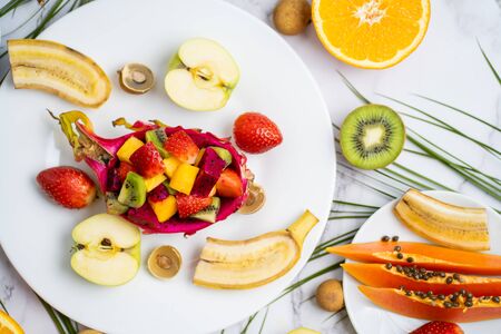 Healthy breakfast from tropical exotic ripe juicy fruits on plates on table. Delicious snack,...