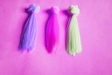Colorful dolls hair on pink backgroundの写真素材