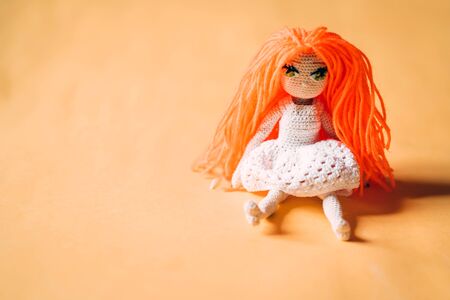 Knitted handmade girl doll with orange hairの写真素材