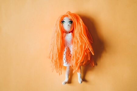 Knitted handmade girl doll with orange hairの写真素材