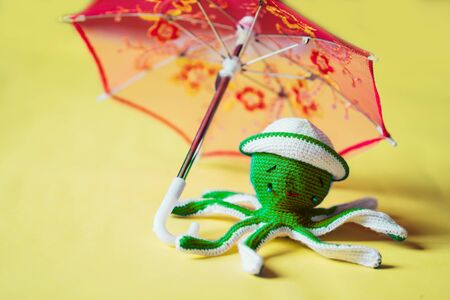 Crochet octopus doll isolated on yellow backgroundの写真素材