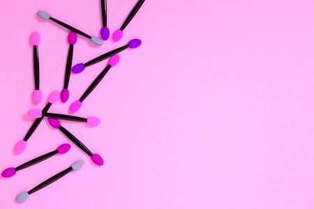 Bunch of purple and colourful eyeshadow brushes on pink background with copy space. makeup, cosmetics, beauty, care conceptの写真素材