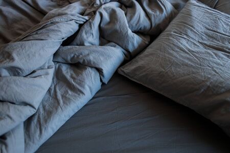 Blue bed sheets and pillows after nights sleep.の写真素材