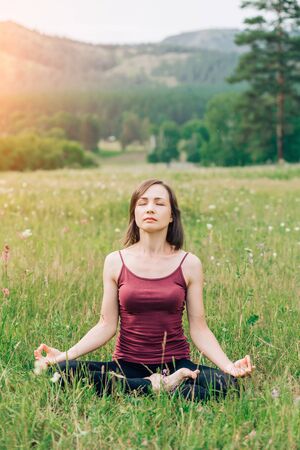Meditating and relaxing woman in nature in summerの写真素材