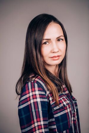 close up portrait of a beautiful young woman looking at the camera on a gray backgroundの写真素材