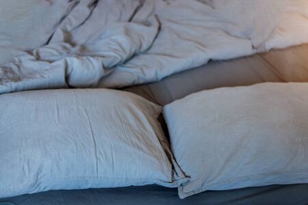 Blue bed sheets and pillows after nights sleep.の写真素材