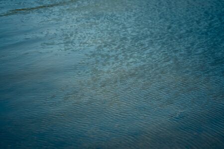 Bright blue background and texture of a river, lake in nature during the wind. Copy space for textの写真素材