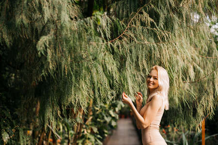 Woman in swimsuit on tropical plants backgroundの写真素材