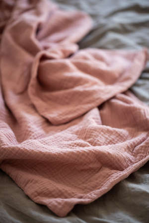 Beautiful pink muslin plaid, blanket, fabric on the bedの写真素材