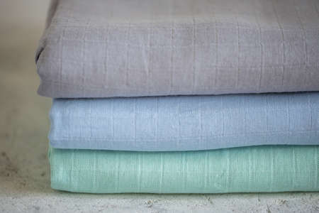 Mint, blue and gray muslin fabric on the table, closeupの写真素材