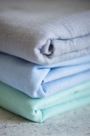 Mint, blue and gray muslin fabric on the table, closeup. Fabric, textiles, clothing conceptsの写真素材