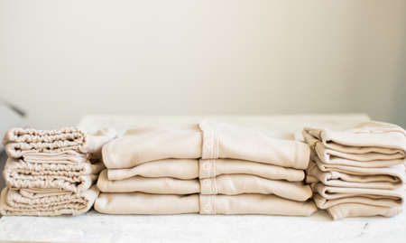 Beautiful beige Baby's clothes on white backgroundの写真素材