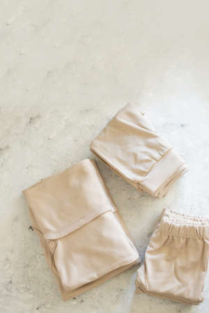 Beautiful beige Baby's clothes on white background top viewの写真素材