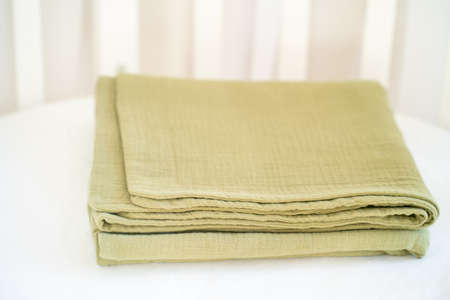 Closeup of a beautiful olive green baby blanket on a white backgroundの写真素材
