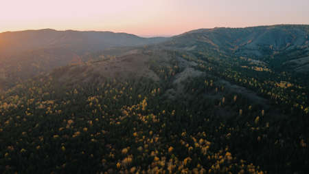Beautiful nature in autumn. High mountains with trees in the sun. Photos from the droneの写真素材