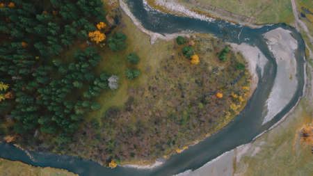 Autumn forest, river, drone. Beautiful top view of autumn nature. Green and yellow trees, river, fieldの写真素材