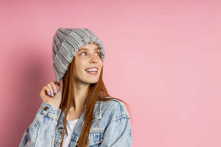 Satisfied lovely European girl with ginger hair, copy space, advertizes something against white background, has playful expression. People and promotion conceptの写真素材