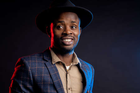 African American man smiling and looking at the camera on a black background, closeupの写真素材