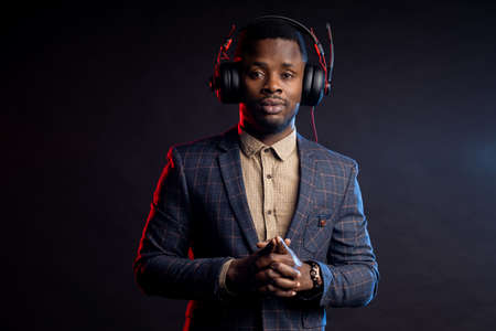 A black man listens to music on a black background. DJ, hangout, hobby conceptsの写真素材
