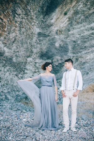 Beautiful couple at the rock looking with a smile at each otherの写真素材