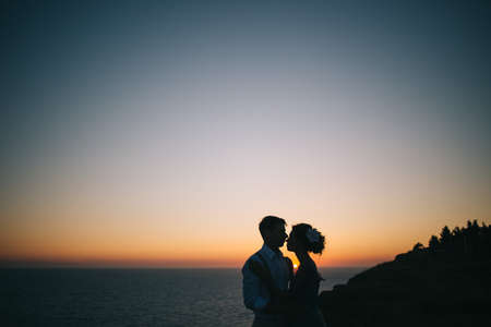 Beautiful couple man and woman on the sunset on the sea. Love, wedding, happiness and family conceptの写真素材