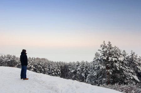 Tourist in blue jeanes and dark jacket standing on hillの写真素材