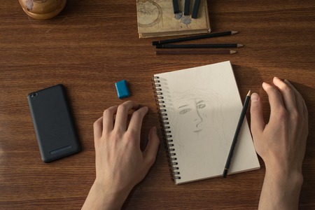 Close-up view of artists or designers table. Pencils, sharpner and eraser.