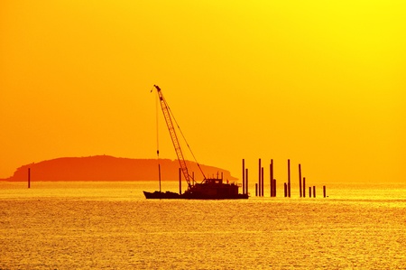 the sea and the sky is orange, a boats and an islands become silhouetteの写真素材