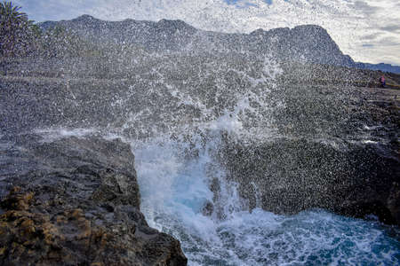 Ocean wave crash on the rock in the volcanic island.の写真素材
