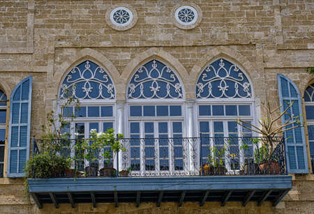 Tel-Aviv - Jaffa, Israel - May 22, 2021: Big glass windows and a balcony of an old house in Jaffa.のeditorial素材