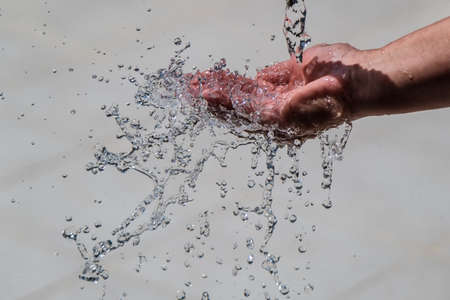 Human hand with water splashing on it.の写真素材