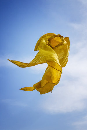 Yellow shirt flying against blue sky.の写真素材