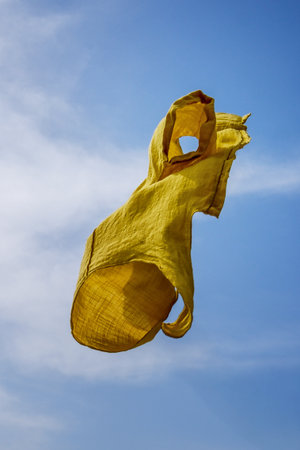 Yellow shirt flying against blue sky.