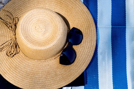 Women's hat and glass on the beach. Travel concept.の写真素材