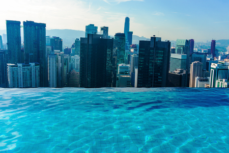 Luxury Swimming pool on rooftop with cityscape of skyscrapers in Kuala lumpurの写真素材