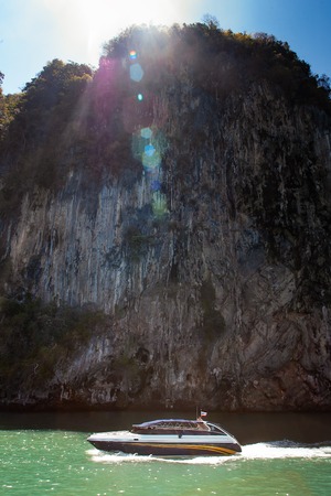 Speedboat near limestone island in bay in Phang Nga National Parkの写真素材