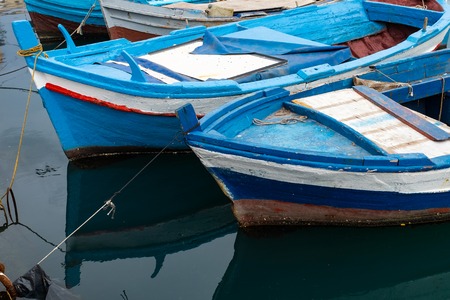Boats docked in a small harbor in a fishing village on the coast of Sicily, Italyの写真素材