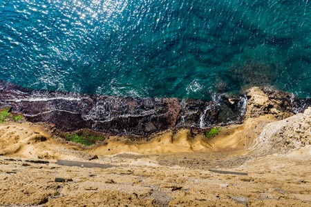Aerial top view of sea with turquoise sea water and rocky coastlineの写真素材