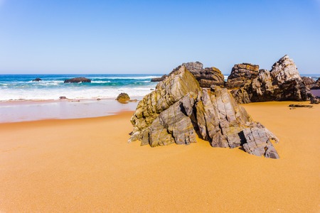 Beautiful sandy beach with rocks on Atlantic coast, Adraga beach, Portugal