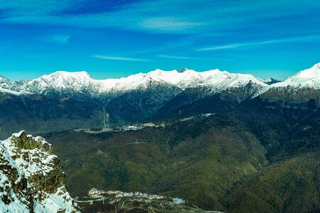 alpine landscape with peaks covered by snow and cloudsの写真素材