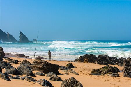 Landscape of portugal rocky beach with fisherman. Portugal coastline.の写真素材