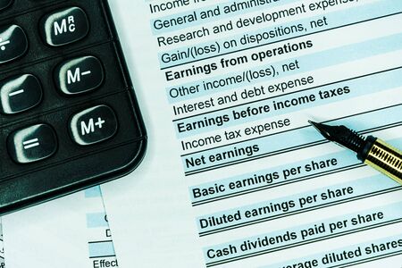 Accounting business concept. Calculator with accounting report and financial statement on desk.の写真素材