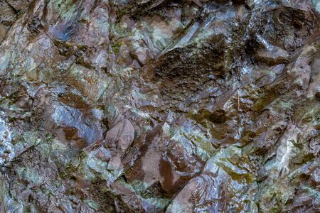 Wet rocky stone, brown colored for background or texture. close-up