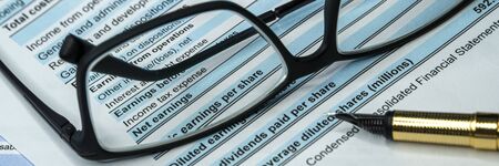 Income statement financial report through glasses. Investment analysis. Wide bannerの写真素材